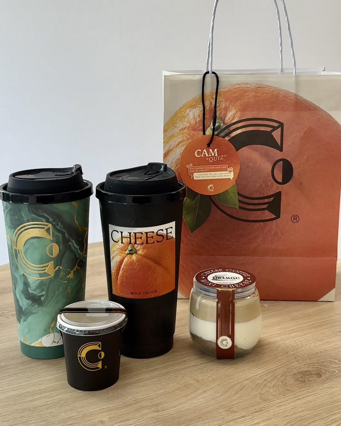 Trà Cam Quýt với vị cam quýt thanh nhẹ, kèm ly “Quấn Quýt” và túi giấy xinh xắn của Cheese Coffee.