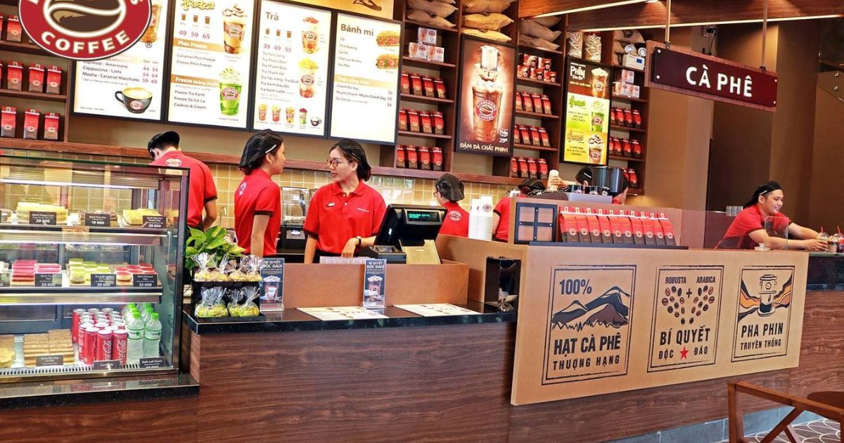 Không gian Highlands Coffee với ly mang về màu đỏ, bảng hiệu thương hiệu rõ ràng, và thiết kế nội thất tạo nhận diện thương hiệu F&B nhất quán.